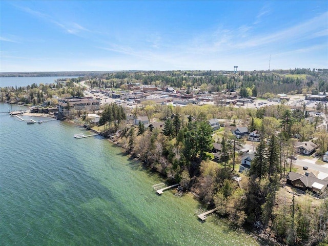 aerial view of property and surrounding area featuring a large body of water and a tree filled landscape