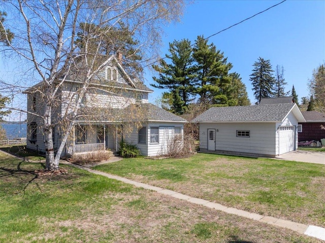 view of front of house featuring a porch, a front lawn, an outbuilding, and driveway