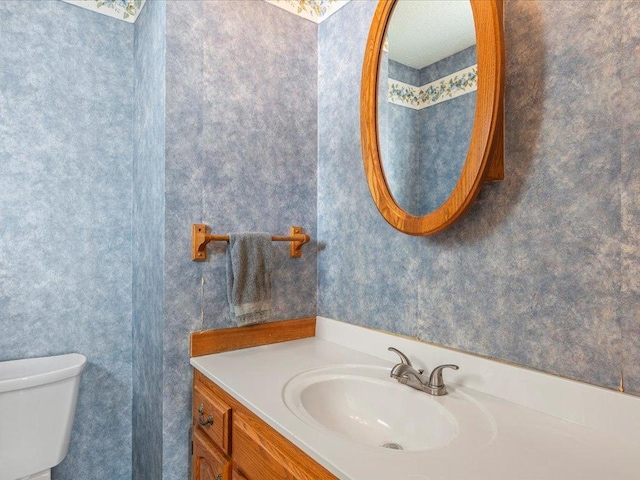 half bathroom featuring toilet and vanity