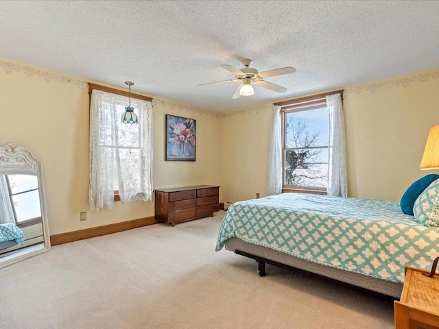 bedroom with multiple windows, carpet, a textured ceiling, a ceiling fan, and baseboards