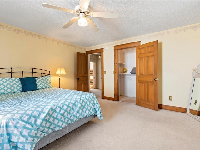 bedroom featuring light colored carpet, a textured ceiling, ceiling fan, a closet, and baseboards