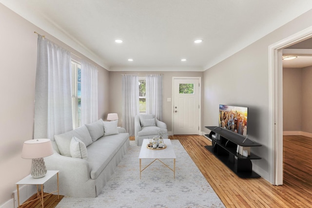 living area with light wood-type flooring, recessed lighting, and baseboards