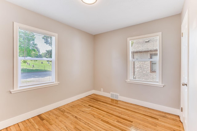 spare room featuring baseboards and hardwood / wood-style flooring