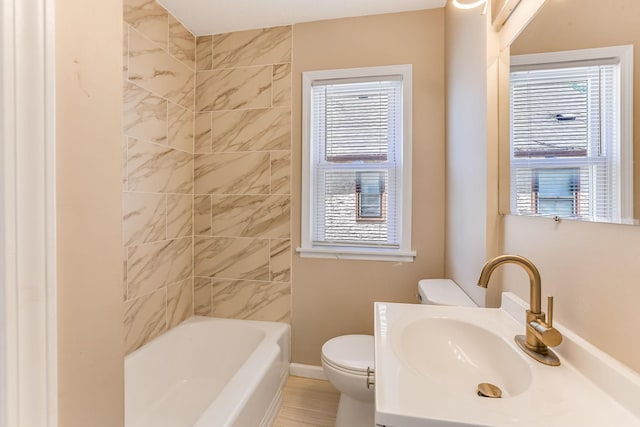 bathroom featuring toilet, healthy amount of natural light, baseboards, and vanity