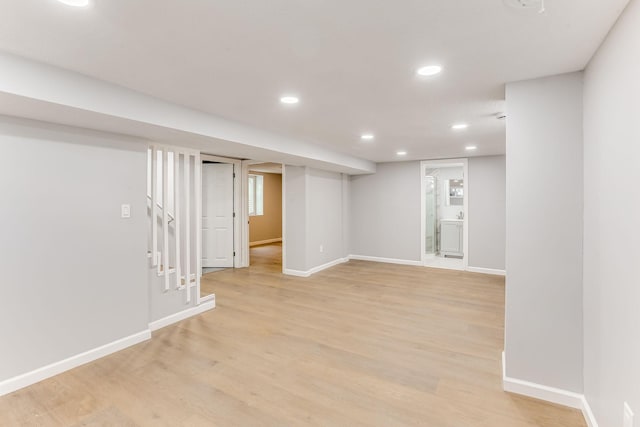 finished below grade area with light wood finished floors, recessed lighting, and baseboards