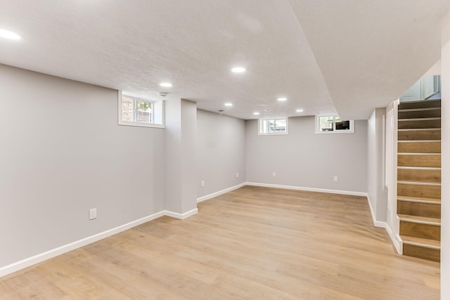 basement with recessed lighting, stairway, light wood-style floors, and baseboards