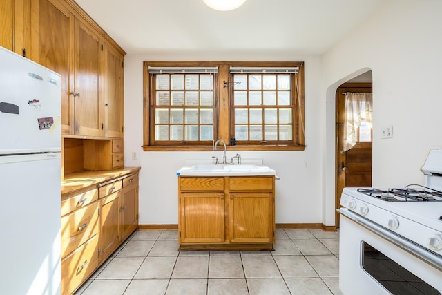 5028-5030 Nicollet Ave S, Minneapolis, MN 55419 - kitchen with white appliances, a sink, arched walkways, and light countertops