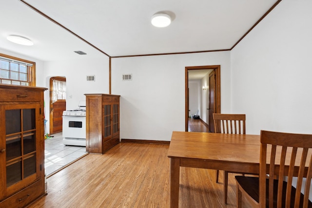 5028-5030 Nicollet Ave S, Minneapolis, MN 55419 - dining area with light wood-style flooring, arched walkways, baseboards, and ornamental molding