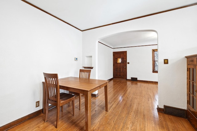 5028-5030 Nicollet Ave S, Minneapolis, MN 55419 - dining space with arched walkways, crown molding, light wood-style floors, and baseboards
