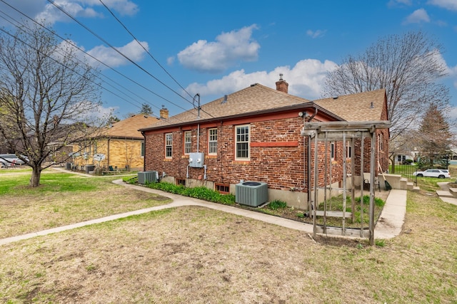 5028-5030 Nicollet Ave S, Minneapolis, MN 55419 - view of side of home featuring a chimney, a lawn, roof with shingles, central AC, and brick siding