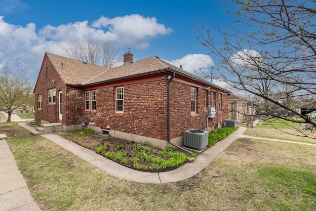 5028-5030 Nicollet Ave S, Minneapolis, MN 55419 - view of home's exterior with a chimney, central air condition unit, brick siding, and a lawn