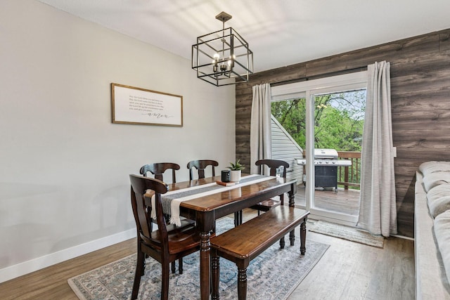 2313 122nd St, Burnsville, MN 55337 - dining area featuring a chandelier, baseboards, and wood finished floors