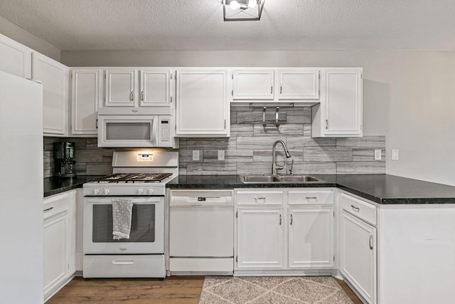 2313 122nd St, Burnsville, MN 55337 - kitchen with white appliances, a sink, white cabinets, decorative backsplash, and dark countertops