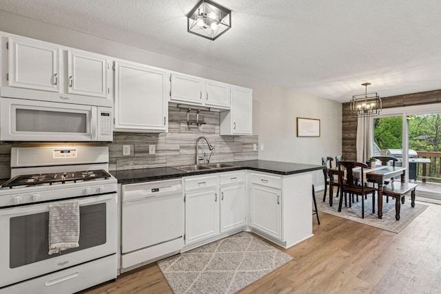 2313 122nd St, Burnsville, MN 55337 - kitchen with white appliances, a sink, a chandelier, white cabinetry, and light wood-type flooring