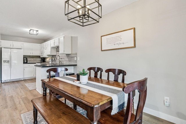 2313 122nd St, Burnsville, MN 55337 - dining room featuring light wood-style flooring, baseboards, and a chandelier