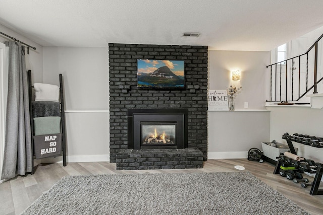 2313 122nd St, Burnsville, MN 55337 - living area with wood finished floors, a fireplace, stairs, and baseboards