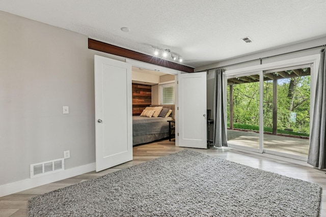 2313 122nd St, Burnsville, MN 55337 - unfurnished bedroom with access to exterior, baseboards, a textured ceiling, and rail lighting