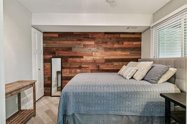 2313 122nd St, Burnsville, MN 55337 - bedroom featuring wooden walls and light wood-type flooring