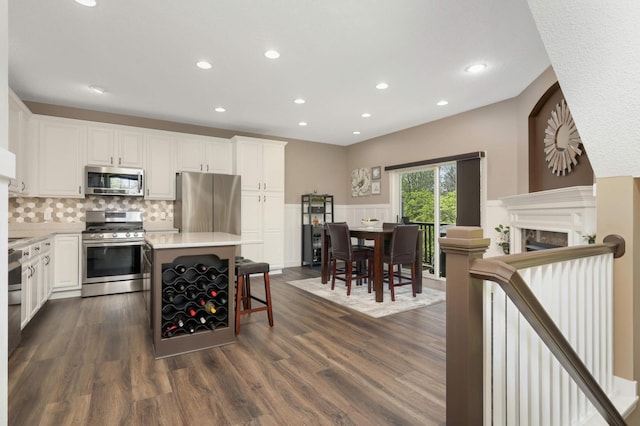 4323 Victor Path Unit 1, Hugo, MN 55038 - kitchen with appliances with stainless steel finishes, recessed lighting, dark wood-style flooring, white cabinets, and decorative backsplash