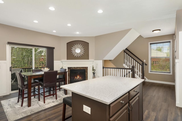 4323 Victor Path Unit 1, Hugo, MN 55038 - kitchen with dark wood finished floors, a glass covered fireplace, recessed lighting, a kitchen island, and light stone countertops