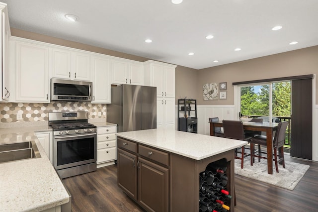 4323 Victor Path Unit 1, Hugo, MN 55038 - kitchen with appliances with stainless steel finishes, dark wood finished floors, wainscoting, white cabinets, and decorative backsplash