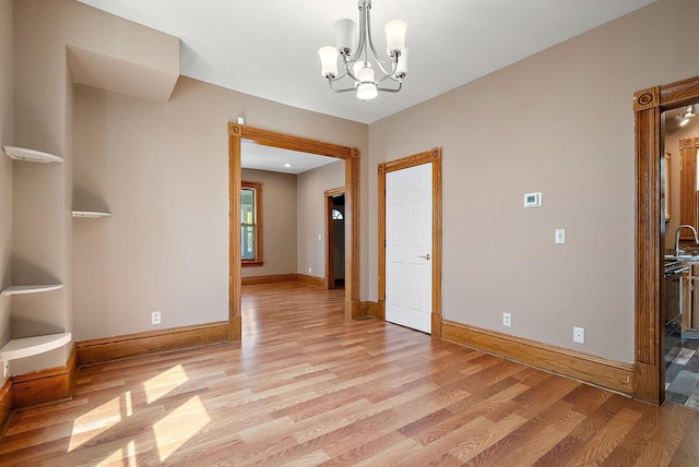 2911 California St NE, Minneapolis, MN 55418 - unfurnished dining area with light wood-type flooring, a chandelier, and baseboards
