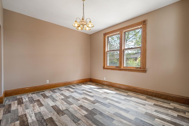 2911 California St NE, Minneapolis, MN 55418 - unfurnished room featuring wood finished floors, a chandelier, and baseboards