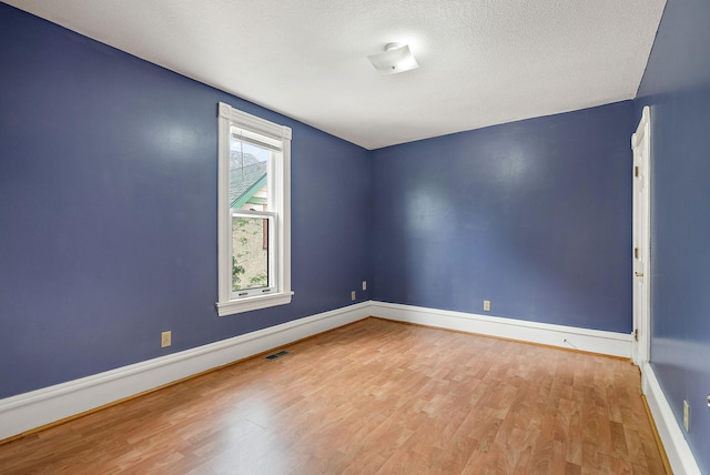 2911 California St NE, Minneapolis, MN 55418 - unfurnished room featuring wood finished floors, baseboards, and a textured ceiling