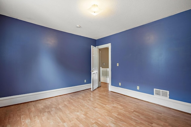 2911 California St NE, Minneapolis, MN 55418 - empty room with wood finished floors, baseboards, and a baseboard heating unit