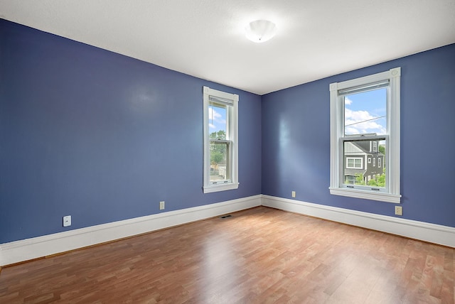2911 California St NE, Minneapolis, MN 55418 - unfurnished room with wood finished floors, plenty of natural light, and baseboards