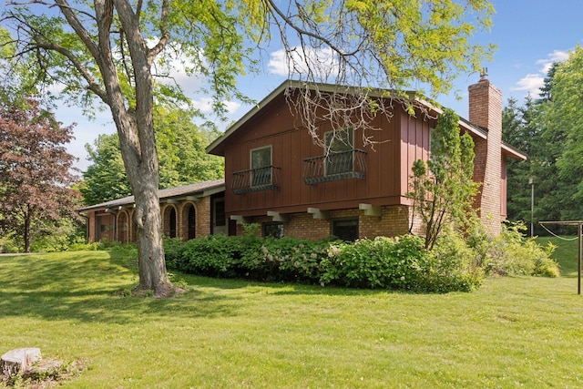 1031 Pheasant Trl, Hudson, WI 54016 - view of property exterior featuring a chimney, brick siding, and a yard