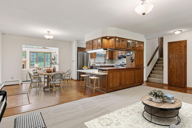 1031 Pheasant Trl, Hudson, WI 54016 - kitchen featuring appliances with stainless steel finishes, brown cabinetry, a peninsula, glass insert cabinets, and a sink