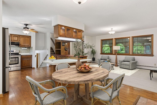 1031 Pheasant Trl, Hudson, WI 54016 - dining room featuring a baseboard heating unit, stairs, hardwood / wood-style floors, and ceiling fan