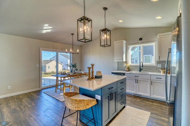 6101 Martin Ln W, West Fargo, ND 58078 - kitchen featuring appliances with stainless steel finishes, a sink, lofted ceiling, white cabinets, and dark wood finished floors