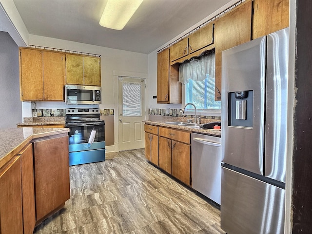 1501 Park St, Fairmont, MN 56031 - kitchen featuring appliances with stainless steel finishes, a sink, and brown cabinets