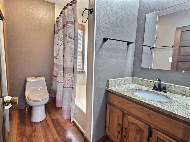 1501 Park St, Fairmont, MN 56031 - full bathroom featuring a textured wall, toilet, wood finished floors, vanity, and shower / bath combo with shower curtain