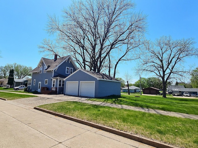 1501 Park St, Fairmont, MN 56031 - view of side of property featuring driveway, a yard, a garage, and a chimney