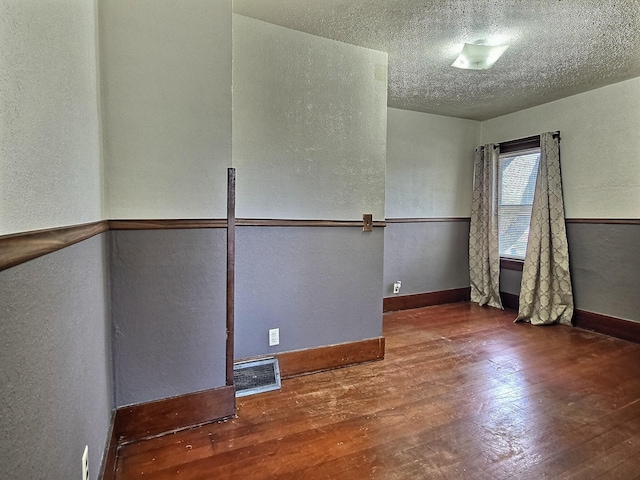 1501 Park St, Fairmont, MN 56031 - empty room with a textured wall, hardwood / wood-style floors, baseboards, and a textured ceiling