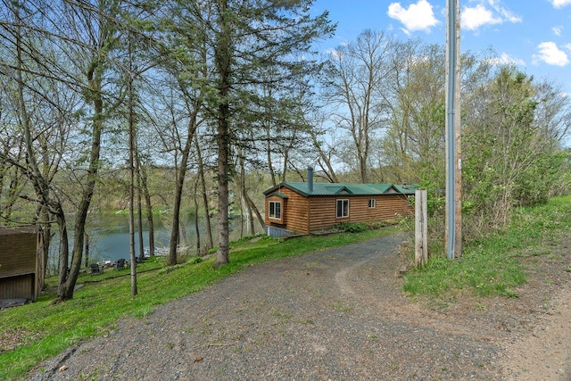 1651 Niles Ln N, Centuria, WI 54824 - view of front of property with a water view, dirt driveway, a chimney, and faux log siding