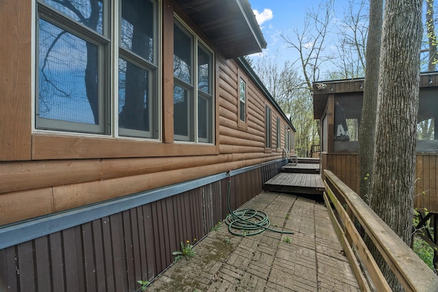 1651 Niles Ln N, Centuria, WI 54824 - view of side of property with log veneer siding and a deck