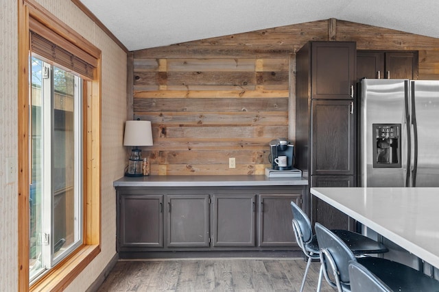1651 Niles Ln N, Centuria, WI 54824 - kitchen with stainless steel refrigerator with ice dispenser, lofted ceiling, wood finished floors, wood walls, and light countertops