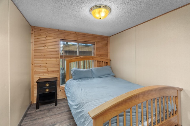 1651 Niles Ln N, Centuria, WI 54824 - bedroom featuring wood finished floors, wooden walls, and a textured ceiling