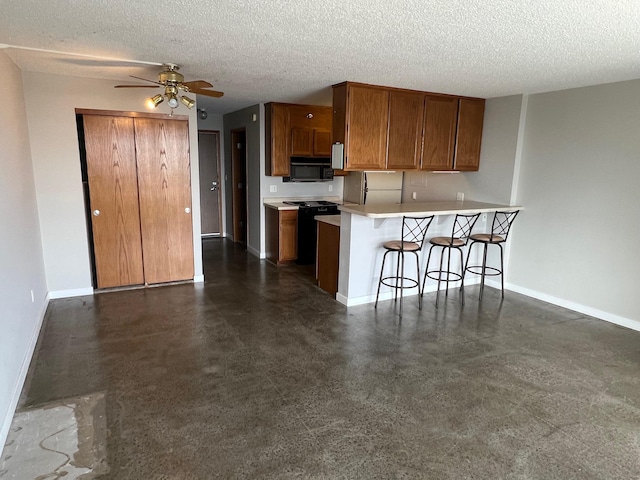 kitchen with black microwave, baseboards, brown cabinetry, ceiling fan, and a breakfast bar