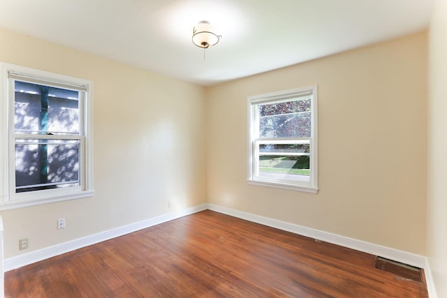 unfurnished room with dark wood-type flooring and baseboards