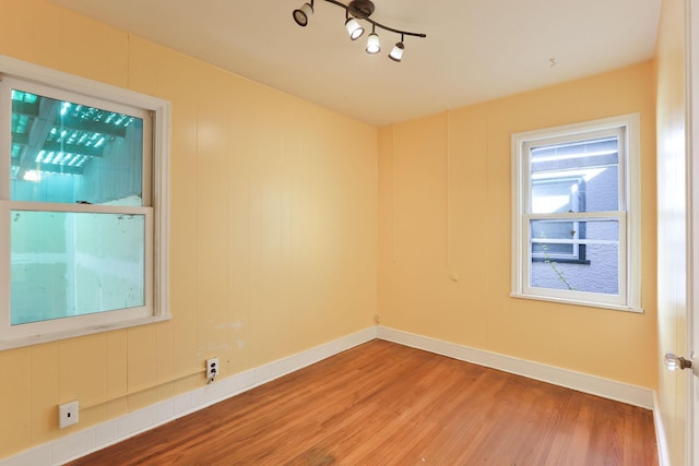 spare room with light wood-style floors and baseboards