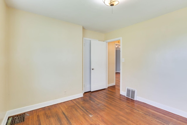 unfurnished room with baseboards and wood finished floors