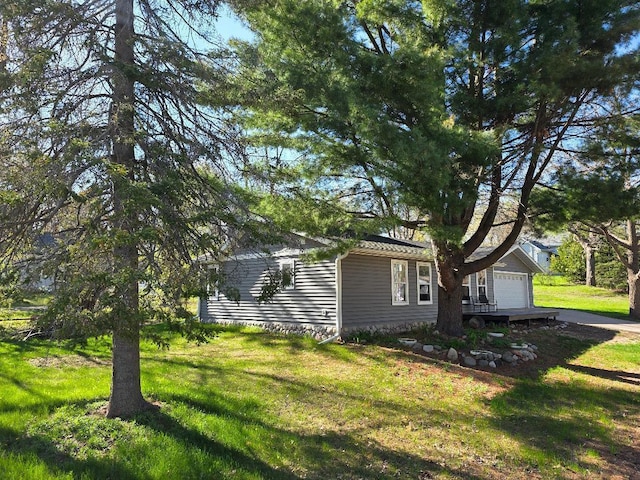 view of side of home with a yard and a garage