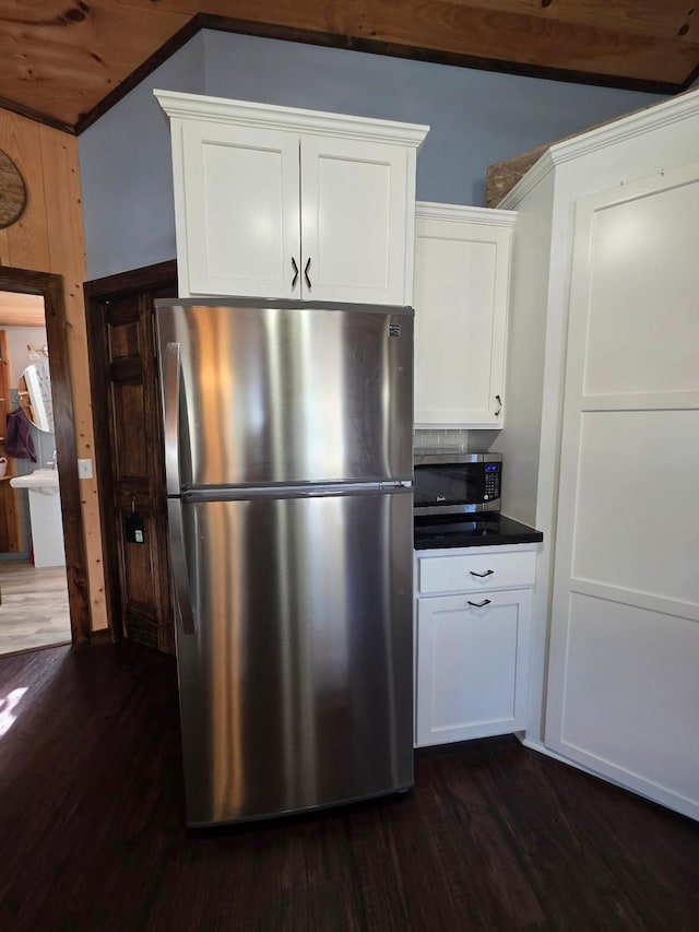 kitchen featuring stainless steel appliances, dark wood finished floors, white cabinets, and dark countertops