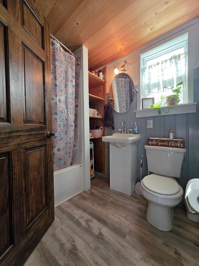 full bath featuring wood finished floors, toilet, a sink, and shower / bathtub combination with curtain
