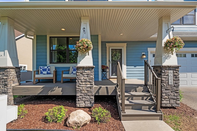 entrance to property with covered porch and a garage
